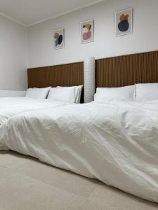 a bedroom with two beds with white sheets at Our Stay in Seoul