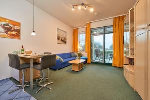 a living room with a blue couch and a table at Strandburg-Küken in Fehmarn