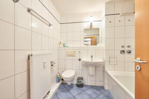 a white bathroom with a toilet and a sink at Strandburg-Küken in Fehmarn +21 photos