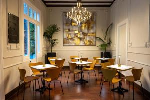 a dining room with tables and chairs and a chandelier at H Ocaranza in Santiago