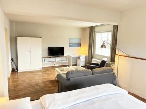 a living room with a couch and a tv at Pier 7 im Pierspeicher in Kappeln