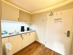 a small kitchen with a sink and a refrigerator at Pier 7 im Pierspeicher in Kappeln