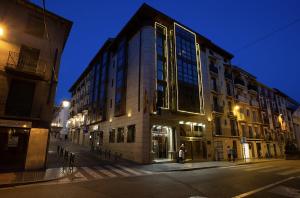 a large building on a city street at night at Hotel Sancho Abarca Petit SPA in Huesca
