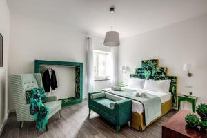 ein Schlafzimmer mit einem Bett, einem Stuhl und einem Spiegel in der Unterkunft Villa Aprea luxury villa with stunning views and private heated pool in Massa Lubrense