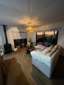 a living room with a white couch and a tv at Casa con espectacular vista Casablanca in Pangue