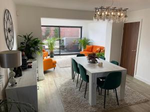 a living room with a table and green chairs at Modern, chic 3-storey town house in Runcorn +21 photos