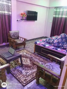 a room with a bed and a couch and a chair at Mahavir home stay in Prayagraj +2 photos