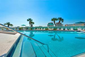 une grande piscine avec chaises et palmiers dans l'établissement Dolphin Point #401C, à Destin
