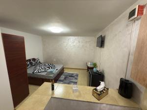 a small room with a bed and a television at Home Efrem in Bucharest