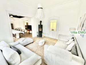 a living room with white furniture and a piano at Villa EMG Düsseldorf Essen Dortmund - Velbert in Velbert