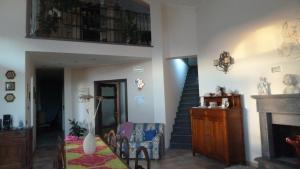 a living room with a staircase and a chair and a fireplace at B&B Il Papavero in Tuscania