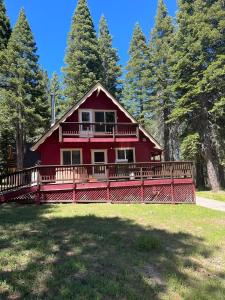 a red house with a large deck in the grass at Cholula Chalet 811C in South Lake Tahoe