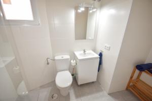 a white bathroom with a toilet and a sink at Ático centro Tarifa in Tarifa +21 photos