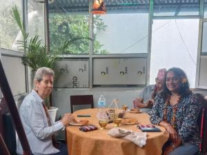 a group of people sitting at a table at Sunrise View Homestay in Tānsen