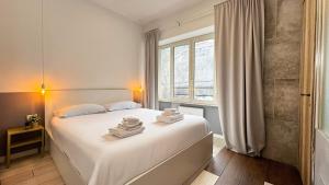 a bedroom with a white bed with towels on it at My Tiny Home in Rome