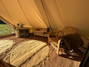 a room with a tent with a chair and a rug at Tribu Lodge in São Bartolomeu de Messines