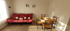 a living room with a red couch and a table at Casa Fundadores in Puerto Montt