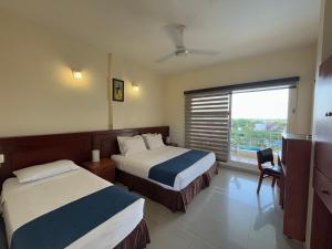 Postel nebo postele na pokoji v ubytování Hotel Los Puentes Comfacundi