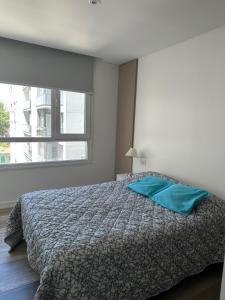 マル・デル・プラタにあるDepartamento con cochera zona Guemesのベッドルーム1室(青い枕付きのベッド1台付)