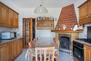 a kitchen with a table with chairs and a fireplace at Casa degli Zii appartamento Letizia in Luni