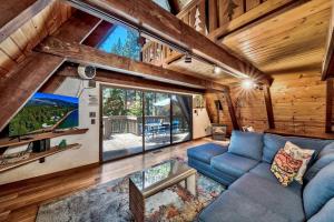 a living room with a blue couch and a large window at 3001R Reindeer A Frame Cabin in South Lake Tahoe