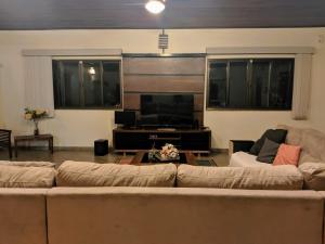 a living room with two couches and a flat screen tv at Chácara Morada do Sol in Sepetiba