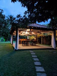 a gazebo with a table and chairs under it at Chácara Morada do Sol in Sepetiba