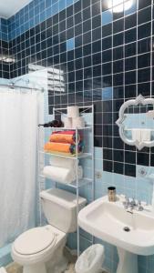 un bagno piastrellato blu con un water e un lavandino di 8 Atlantic Place by Stay with Bear a San Juan