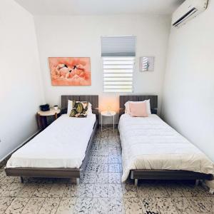 due letti in una stanza con pareti bianche di 8 Atlantic Place by Stay with Bear a San Juan