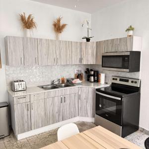 una cucina con armadi in legno e un apparecchio nero di 8 Atlantic Place by Stay with Bear a San Juan