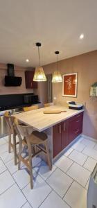 a kitchen with a wooden table and two lights at Terracotta - Séjour à Auxerre in Auxerre