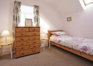 a bedroom with a bed and a dresser and a window at 1a Park Lane in Southwold