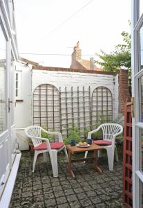 a patio with two chairs and a table and a table and chairs at 1a Park Lane in Southwold