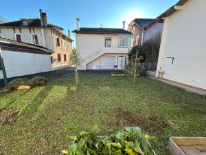 a yard with two trees in the middle of two buildings at Le Chalet - maison avec jardin et parking in Lourdes
