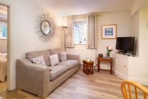 Una sala de estar con un sofá y un televisor. en Thomas Fold Flat, en Ambleside