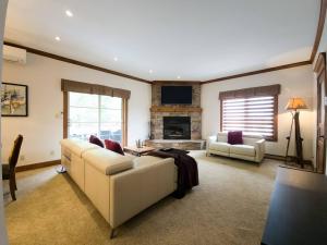 a living room with a couch and a fireplace at Stunning 3bdr with Private Sauna - Plateau 202-5 in Mont-Tremblant