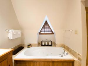 a bathroom with a large bath tub with a window at Stunning 3bdr with Private Sauna - Plateau 202-5 in Mont-Tremblant