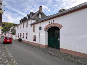 a red car parked in front of a white building at Apartment Eifelsteig im Posthalterhof, anno 1683, mit Sauna in Blankenheim
