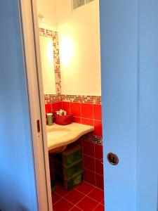 a red bathroom with a sink and a mirror at Palumbalza Marinella sea in Marinella +60 photos