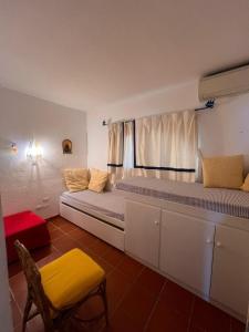 a room with two beds with a window and a chair at Palumbalza Marinella sea in Marinella