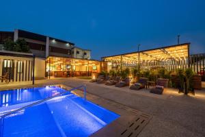 a swimming pool in front of a building at night at Eden Gardens Hotel in Accra