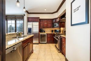 a kitchen with wooden cabinets and stainless steel appliances at Luxury 3 bdr on the village - Bondurant 95-15 in Mont-Tremblant +17 photos