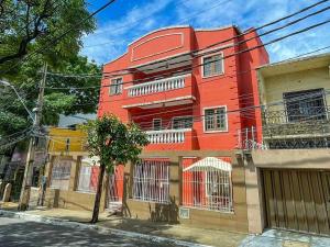 福塔莱萨Refúgio Pousada Fortaleza的街道边的红色建筑
