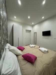 a large bed with pillows on it in a room at Il Tulipano house in Catania