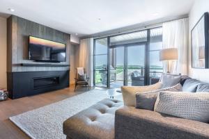 a living room with a couch and a tv at Luxury Living on the Slopes - Horizon 2-204 in Mont-Tremblant