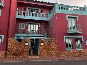 マロにあるEstudio 1 en Maro con vistas al mar y balcónの赤い建物(バルコニー付) +4枚の写真