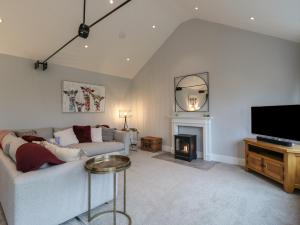ein Wohnzimmer mit Couch und Kamin in der Unterkunft Barley Cottage in Huntingdon