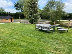 a picnic table and benches in a grass field at ENTRE PARENTHESE - Gîte "Enjoy" in Warlus
