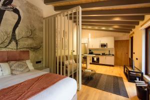 a bedroom with a large bed and a kitchen at Casa Escondida Aveiga in Chantada