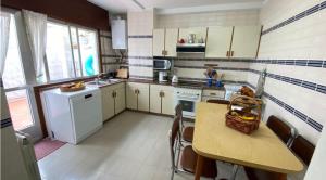 a kitchen with a table and a sink and a stove at Apartamento PANXOLIÑAS in Panjón +5 photos